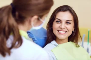 Oral Surgery 1 A woman smiles in a dentist’s chair after getting oral surgery