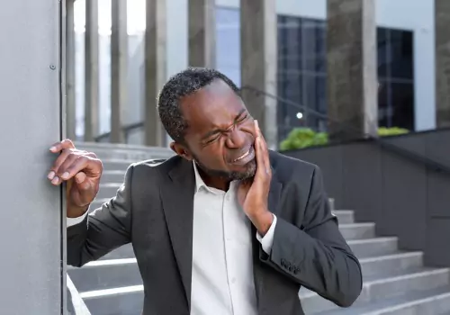 A man holding his mouth in pain, needing Emergency Treatment for his teeth 