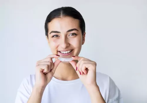 Smiling woman about to put her Night Guards in her mouth