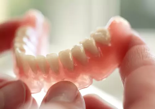 Man holding Dentures for bottom row of teeth