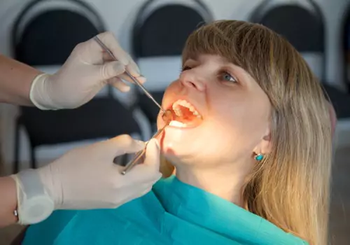 Dentist inspecting a mouth as part of Oral Cancer Screenings in Peoria IL