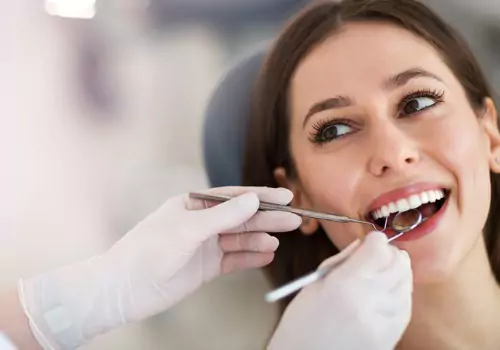 A dentist examining the teeth of a woman who got dental Crowns & Bridges in Peoria IL