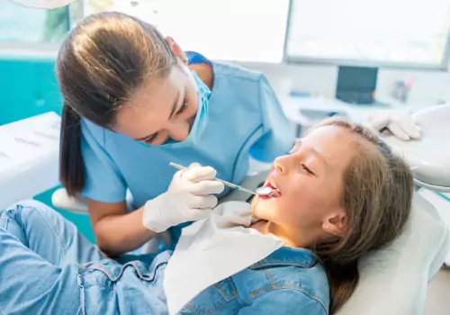 A dentist checking a child's fillings that use Silver Diamine Fluoride in Peoria IL