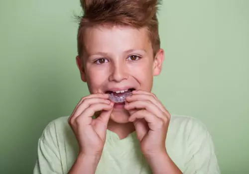 Young boy putting on Mouthguards in Peoria IL