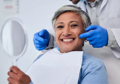 A happy, smiling elderly woman after having her teeth cleaned by a Dentist Near You