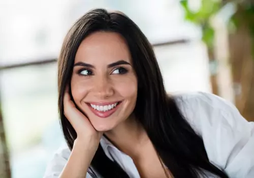 A woman showcases her perfect smile. he Smile Center is a holistic dental office in East Peoria IL.