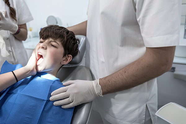 A boy is worried about dental pain ahead of an emergency treatment.