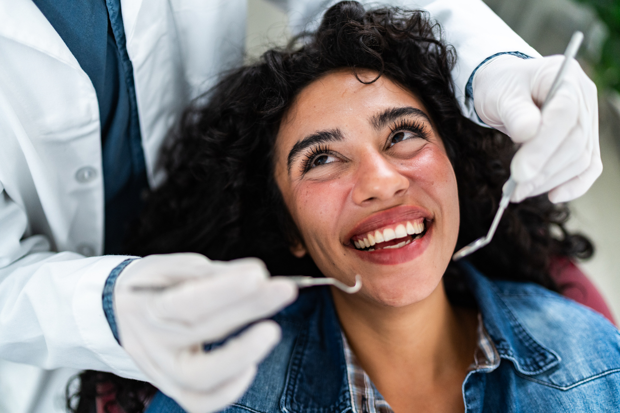 A woman smiles at the dentist after learning how to find a good dentist