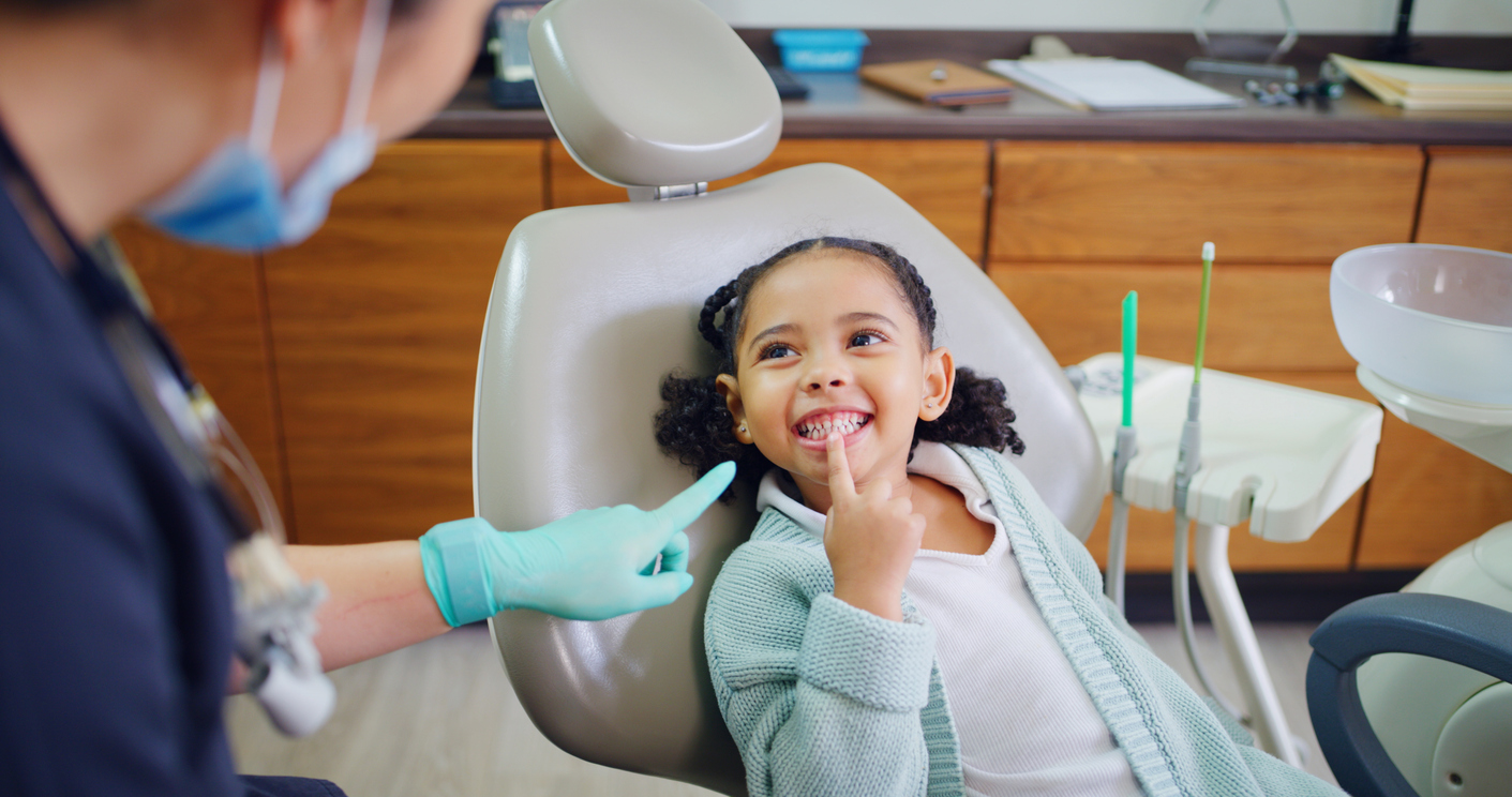 A child smiles at her dental team after her mother searched for how to find a good dentist